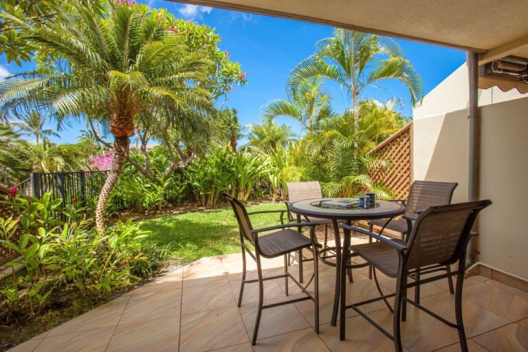 Maui Kamaole - Condo, lanai with chairs with palm tree courtyard.