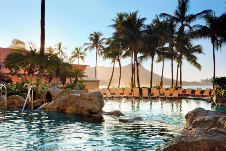 View of Hawaii hotel pool with palm trees and Diamond Head in background.
