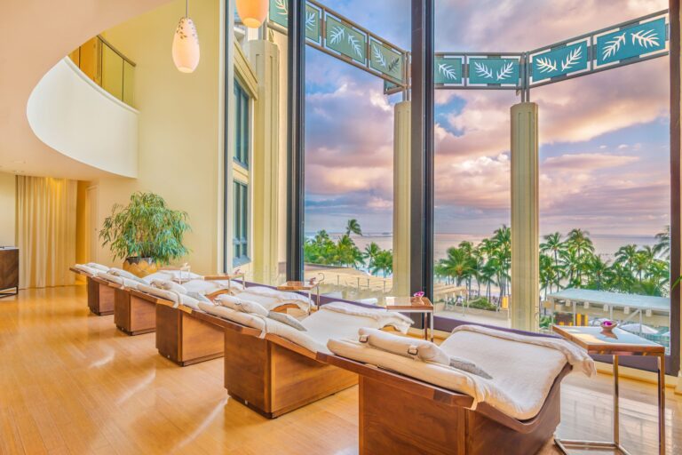Image of row of spa chairs looking out large picture glss window overlooking beach.