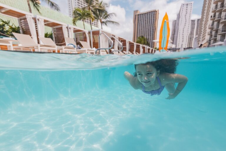 Girl swimming underwater at Waikiki resort pool