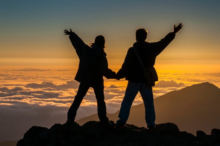 Orange sunset with silouette of couple on top of Haleakala Mountain, Maui, Hawaii