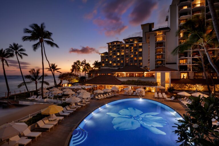 pool at night, orchid motif at bottom of pool, palm trees